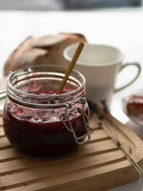 Glas mit Marmelade auf einem Holzbrett