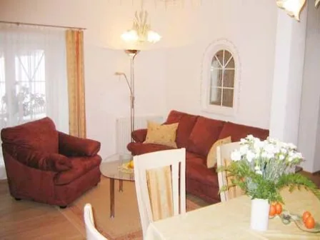 Wohnraum des Appartements mit rotem Sofa und Rundbogenfenster